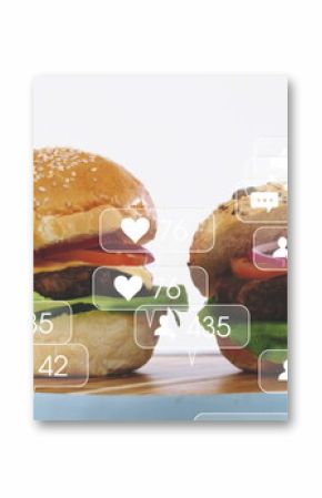 Stacking beef burgers layering lettuce tomato cheese onion on wood board, with social media icons