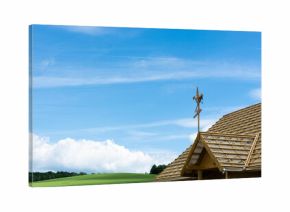 budowa domu, wiecha na dachu, w tle pola i niebieskie niebo