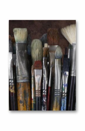 Close up of artist paint brushes with dark textured background