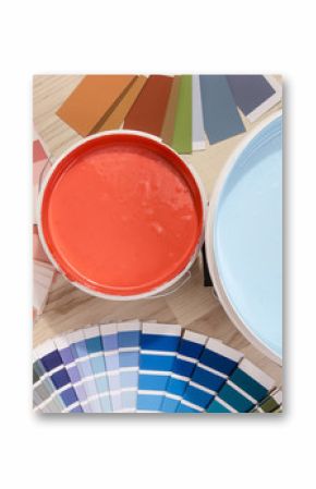 Blue and red paint cans and samples with different color shades with paint roller and accessories. Swatches and paint on the floor.