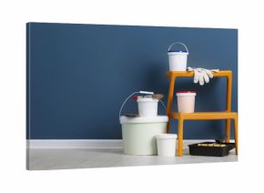 Set with decorator tools and paint on floor near color wall