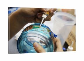 painting with  stained glass paints and line paints on transparent blue glass jar
