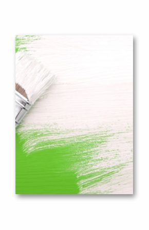 Paintbrush with white paint painting over green