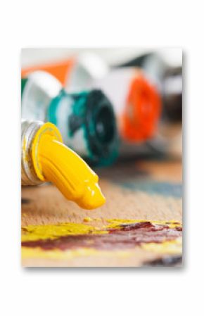 Oil paint tubes and pain brush over colorful artist's palette