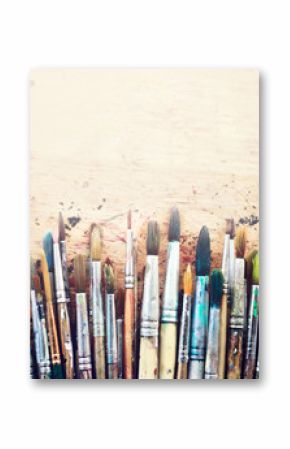 Group of old used paint brushes  on a rustic wooden table. 