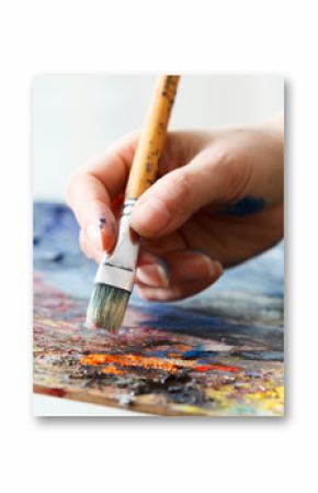 Artist paints a picture of oil paint brush in hand with palette