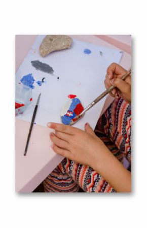 child painting stones outdoors