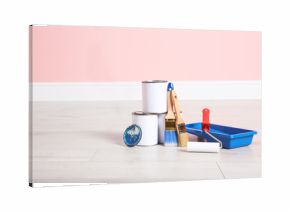 Cans of paint and decorator tools on wooden floor indoors. Space for text