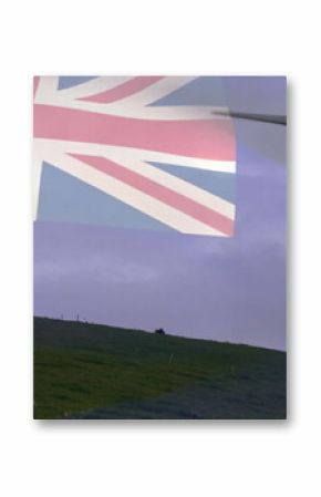 Standing wind turbine towering on rural grassy hill, with Australian flag overlay, copy space