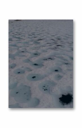 Displaying snow-covered ice sheet revealing melt holes on frozen expanse, with red blue line graphs