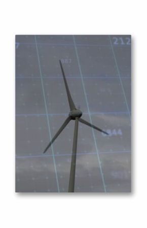 Displaying three-blade wind turbine spinning in rural area, with digital grid overlay of data