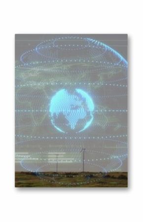 Displaying digital globe with orbital rings rotating above rural wind farm turbines and power poles
