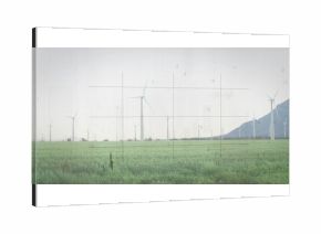 Featuring wind turbine spinning above grassland at wind farm, with mountain ridge, grid overlay