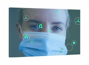 Mid-adult researcher wearing surgical mask analyzing floating energy and eco icons in clinic