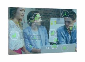 Colleagues exploring renewable energy and CO2 charts in office, with laptop and whiteboard notes