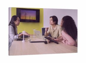 Collaborating team in boardroom wearing formal wear discussing renewable energy with scale models