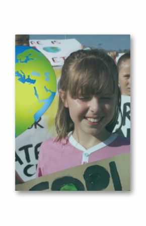 Image of heart shaped earth over caucasian children with climate change signs on protest march