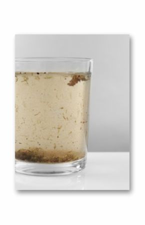 Glass of contaminated water on grey background