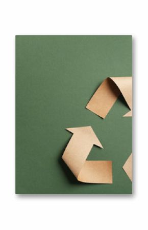 Recycling symbol cut out of kraft paper on green background, top view. Space for text