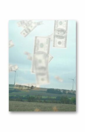 Floating cluster of US dollar bills hovering above farmland, with turbines, hedgerows and rooftops
