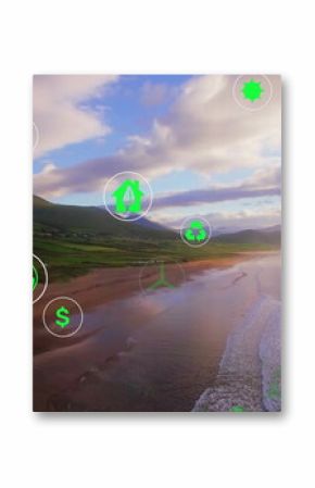 Showing wind, solar, recycling, radiation and dollar icons floating over coastal beach at dusk