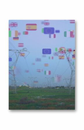 Displaying steel lattice towers carrying power lines across grassland at dusk, with European flags
