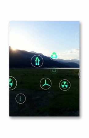 Displaying mountain ridge overlaying sustainability and energy icons over plain and lake at sunrise