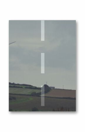 Displaying wind turbine on farmland with hedgerows under translucent road overlay and tree icons
