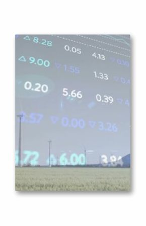 Displaying row of wind turbines rotating in grassland by mountain ridge, with stock ticker overlay