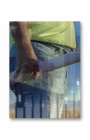 Holding blueprint, engineer wearing neon shirt surveying grass by turbines with overlay, copy space