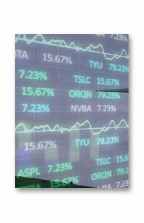 Merging modern 3-blade wind turbine standing on grassy hill, overlaying stock tickers and graphs