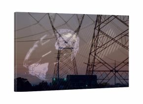 Silhouetting towers and high-voltage lines at power station, lit building and globe overlay