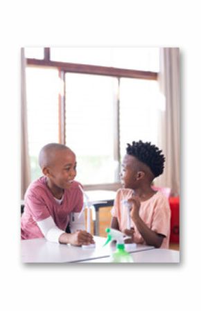 In school, two african american boys discussing wind turbine models in classroom