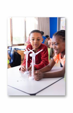 Building wind turbine models in school classroom, diverse children engaging in STEM activities