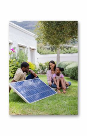 Family enjoying outdoor time learning about solar panel technology in garden, copy space