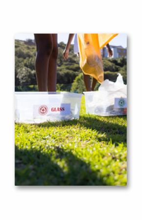 Recycling at school, diverse girls sorting glass and paper into separate bins