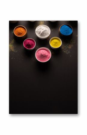 Close up of multi coloured powder in bowls and copy space on black background