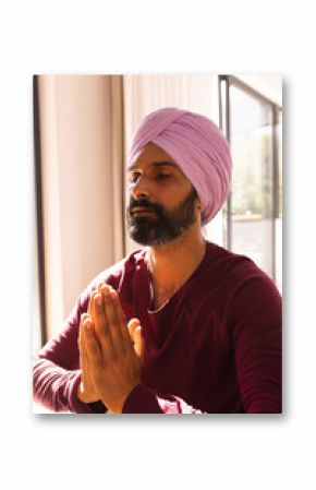 Meditating, man in turban practicing mindfulness with hands in prayer position