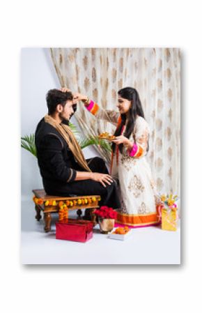 Indian young sister tying rakhi on brother's wrist, a tradition on Raksha Bandhan festival