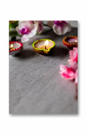 Close up of diwali candles and flowers with copy space on grey background