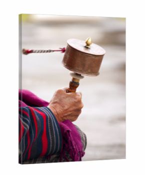 An older women spinning her prayer wheel