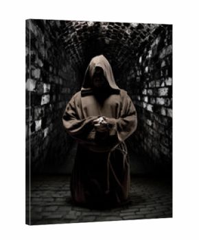 Praying monk in dark temple corridor