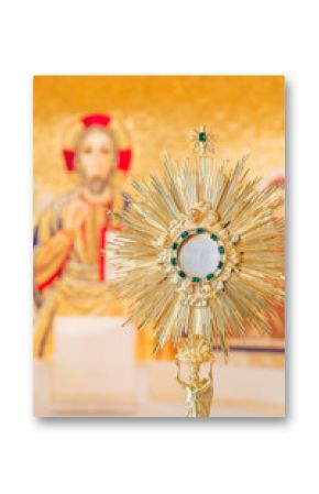 Eucharistic adoration monstrance on the altar with the image of Jesus Christ in the background