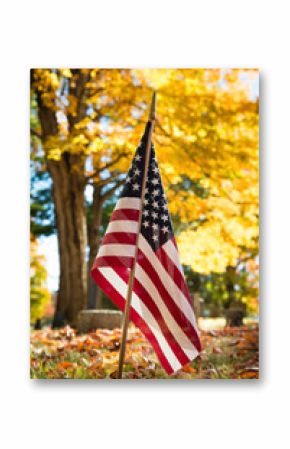 Closeup of American veteran flag in autumn cemetery