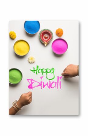 Stock Photo of happy diwali greeting card clicked using elements of Diwali festival like colourful rangoli in bowls, diwali clay lamp or diya and girl or girl making rangoli, writing happy diwali    