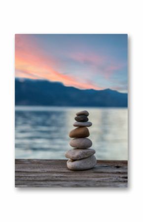 Stones pyramid on wooden pier, relaxation harmony background