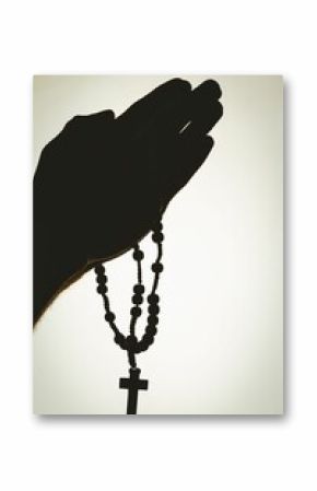 Solhouette hand with rosary praying