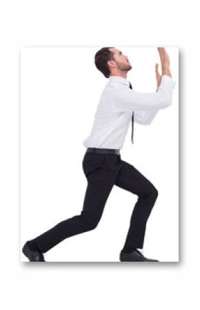 Businessman standing with bent legs and pushing