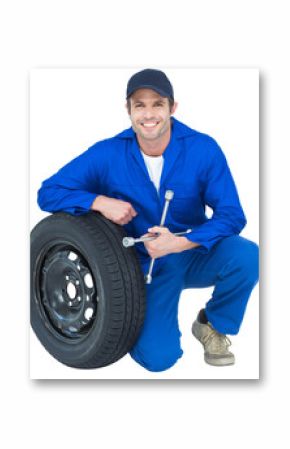Mechanic leaning on tire while holding wheel wrenches
