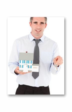 Businessman holding a key and a miniature house
